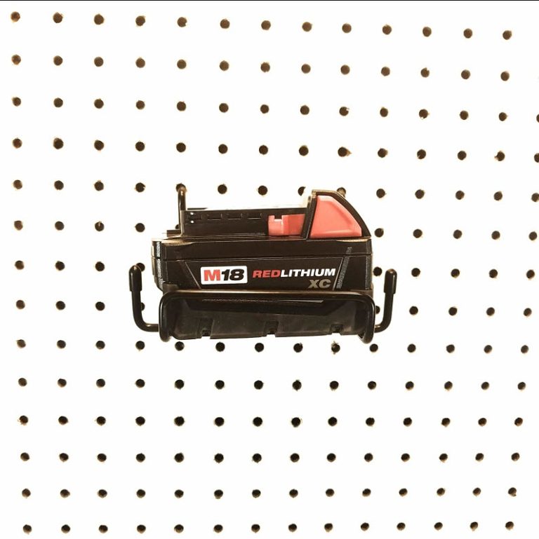 Milwaukee battery packs stored on pegboard wall hangers