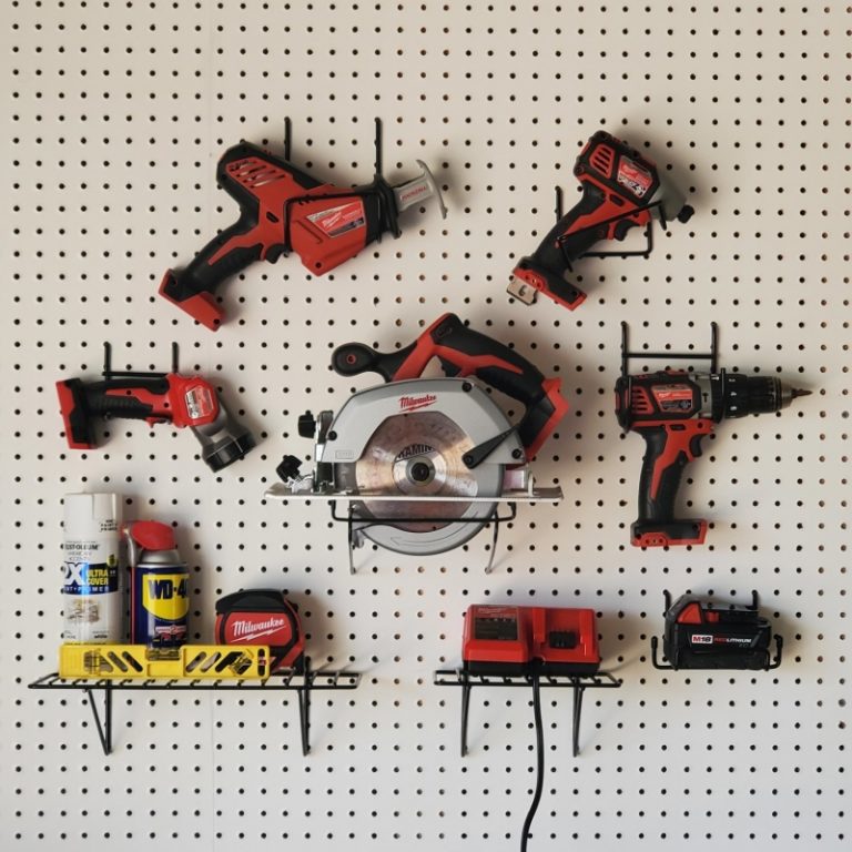 Milwaukee power tools hanging on pegboard with heavy-duty steel hangers